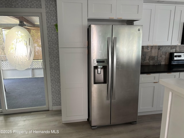 12325 Fairway Ave, Brooksville, FL 34613 - kitchen with stainless steel refrigerator with ice dispenser, wallpapered walls, light wood-type flooring, white cabinetry, and tasteful backsplash
