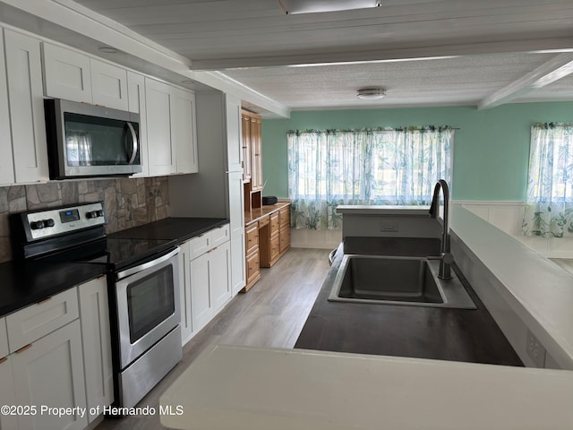 12325 Fairway Ave, Brooksville, FL 34613 - kitchen with appliances with stainless steel finishes, beam ceiling, white cabinetry, decorative backsplash, and dark countertops