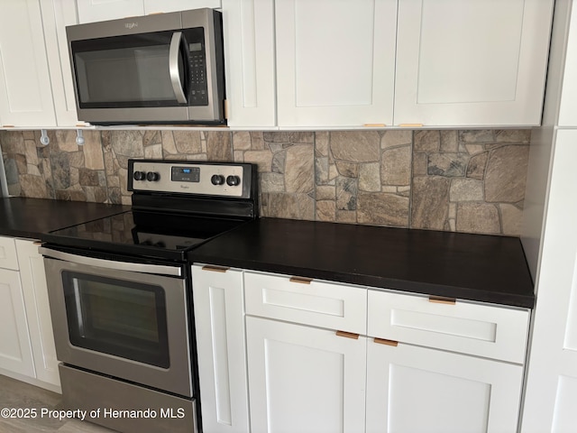 12325 Fairway Ave, Brooksville, FL 34613 - kitchen featuring appliances with stainless steel finishes, dark countertops, white cabinetry, and decorative backsplash