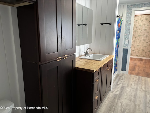 12325 Fairway Ave, Brooksville, FL 34613 - full bathroom with wallpapered walls, wood finished floors, vanity, and curtained shower