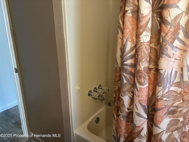 12325 Fairway Ave, Brooksville, FL 34613 - bathroom with shower / bath combo with shower curtain and wood finished floors