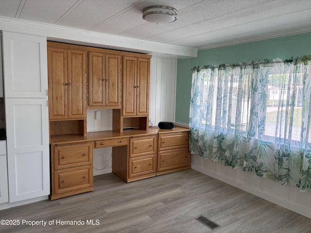 12325 Fairway Ave, Brooksville, FL 34613 - home office with crown molding, built in study area, light wood finished floors, and a textured ceiling