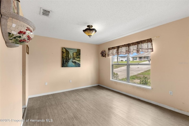 4148 Landover Blvd, Spring Hill, FL 34609 - empty room featuring wood finished floors, a textured ceiling, and baseboards