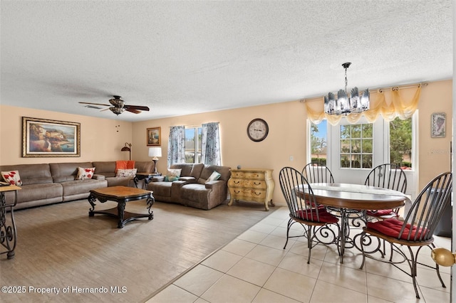4148 Landover Blvd, Spring Hill, FL 34609 - living room with healthy amount of natural light, a textured ceiling, a chandelier, ceiling fan, and light tile patterned floors