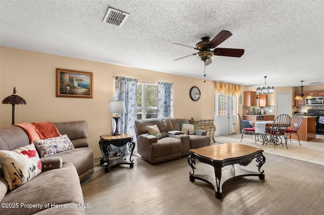 4148 Landover Blvd, Spring Hill, FL 34609 - living area with ceiling fan, a chandelier, a textured ceiling, and light wood finished floors