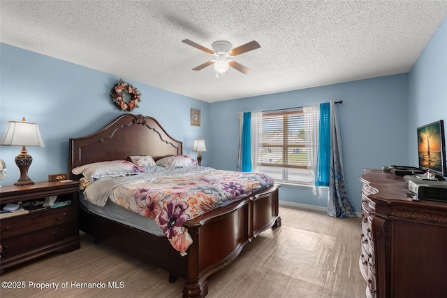 4148 Landover Blvd, Spring Hill, FL 34609 - bedroom with light wood-style flooring, a textured ceiling, ceiling fan, and baseboards