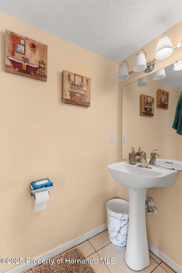 4148 Landover Blvd, Spring Hill, FL 34609 - bathroom with a textured ceiling, tile patterned floors, baseboards, and a sink