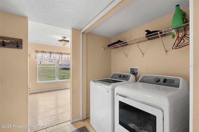 4148 Landover Blvd, Spring Hill, FL 34609 - laundry room featuring washing machine and clothes dryer, a textured ceiling, and light tile patterned floors