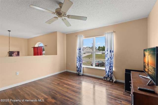 4148 Landover Blvd, Spring Hill, FL 34609 - unfurnished living room featuring a textured ceiling, wood finished floors, a ceiling fan, and baseboards