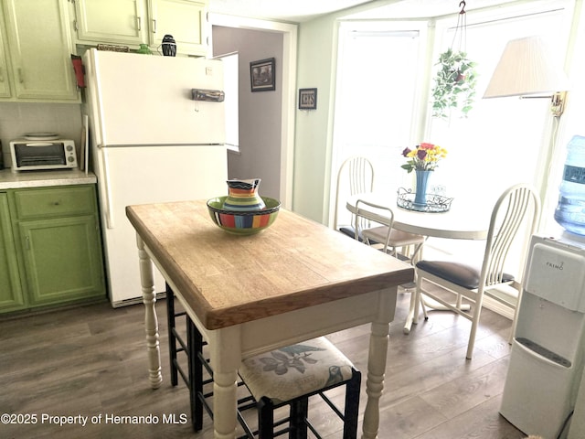 11087 Addison St, Spring Hill, FL 34609 - kitchen with green cabinetry, freestanding refrigerator, dark wood-style floors, and light countertops