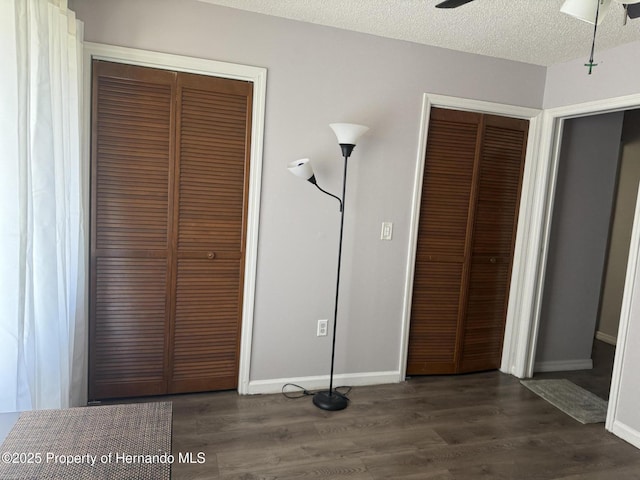 11087 Addison St, Spring Hill, FL 34609 - unfurnished bedroom featuring multiple closets, dark wood finished floors, and a textured ceiling