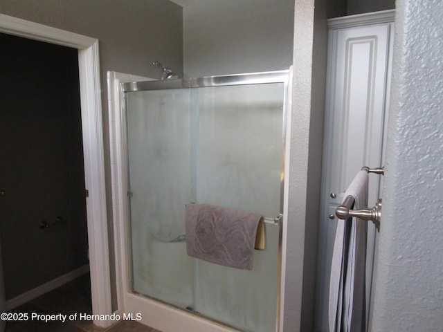 8423 Dickens Ave, Brooksville, FL 34613 - bathroom featuring a shower stall and a textured wall