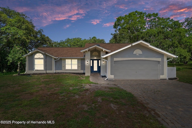 204 Oak Lake Dr, Spring Hill, FL 34608 - single story home featuring a garage, decorative driveway, a yard, and stucco siding