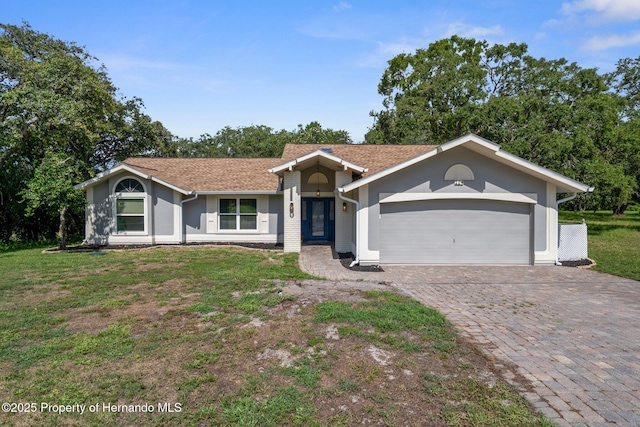204 Oak Lake Dr, Spring Hill, FL 34608 - ranch-style house featuring a garage, decorative driveway, a front lawn, and stucco siding
