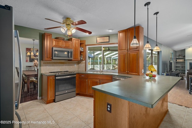 204 Oak Lake Dr, Spring Hill, FL 34608 - kitchen featuring appliances with stainless steel finishes, brown cabinets, ceiling fan, backsplash, and a peninsula