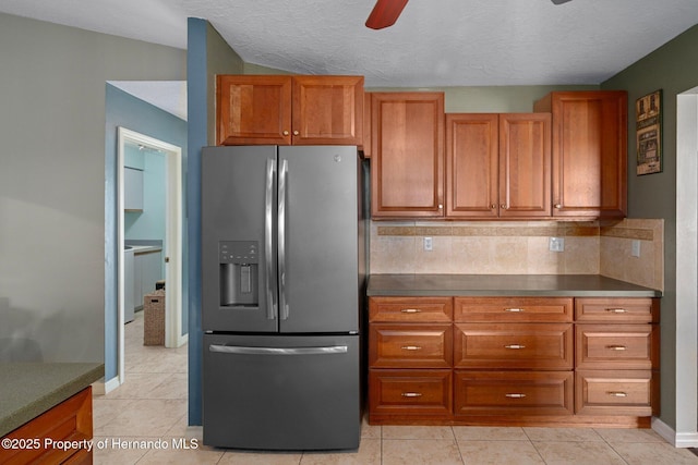 204 Oak Lake Dr, Spring Hill, FL 34608 - kitchen with stainless steel fridge, ceiling fan, brown cabinetry, decorative backsplash, and dark countertops