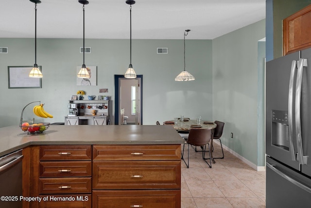 204 Oak Lake Dr, Spring Hill, FL 34608 - kitchen featuring appliances with stainless steel finishes, light tile patterned floors, brown cabinetry, and hanging light fixtures