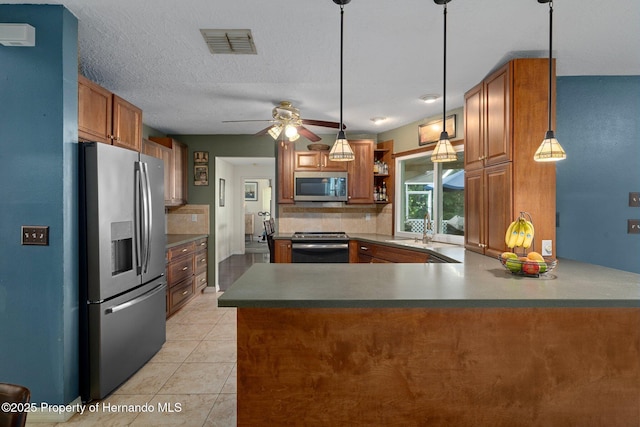 204 Oak Lake Dr, Spring Hill, FL 34608 - kitchen with appliances with stainless steel finishes, decorative backsplash, brown cabinets, ceiling fan, and a peninsula