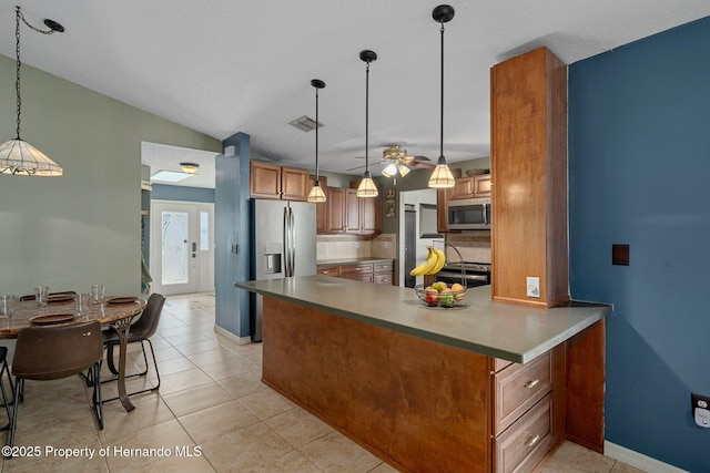 204 Oak Lake Dr, Spring Hill, FL 34608 - kitchen with stainless steel appliances, brown cabinets, ceiling fan, decorative light fixtures, and light tile patterned floors