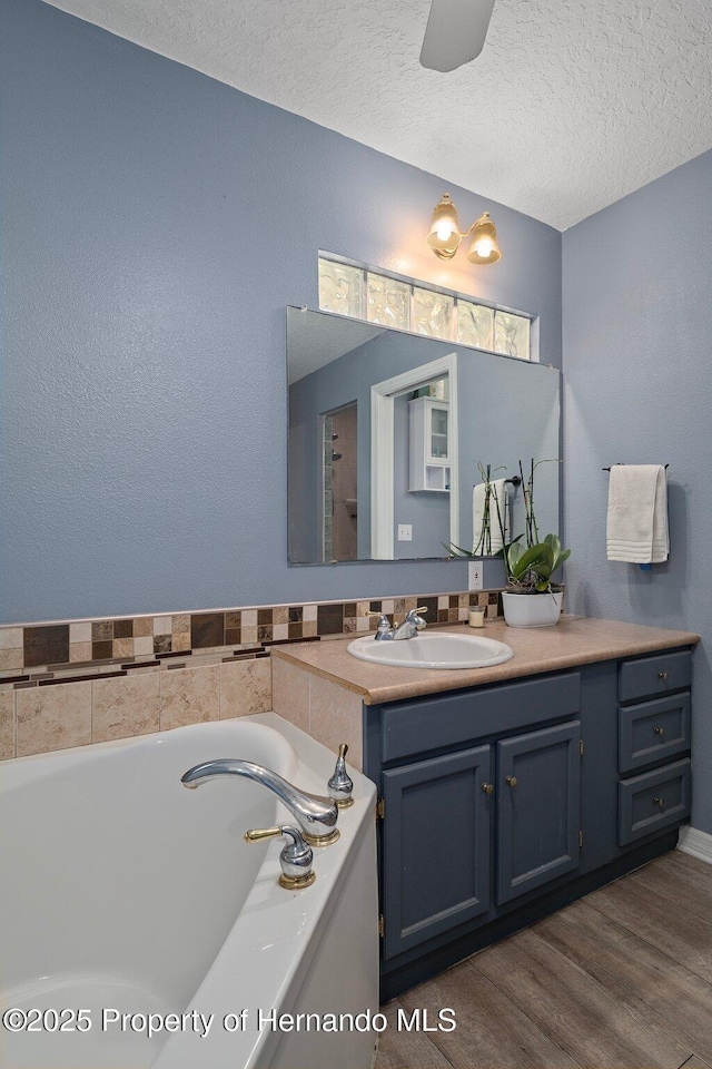 204 Oak Lake Dr, Spring Hill, FL 34608 - full bath featuring vanity, a garden tub, a textured ceiling, and wood finished floors