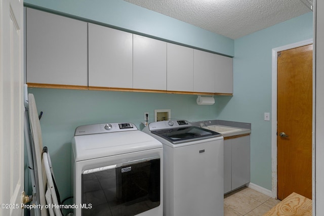 204 Oak Lake Dr, Spring Hill, FL 34608 - laundry room with cabinet space, washer and clothes dryer, a textured ceiling, and light tile patterned floors