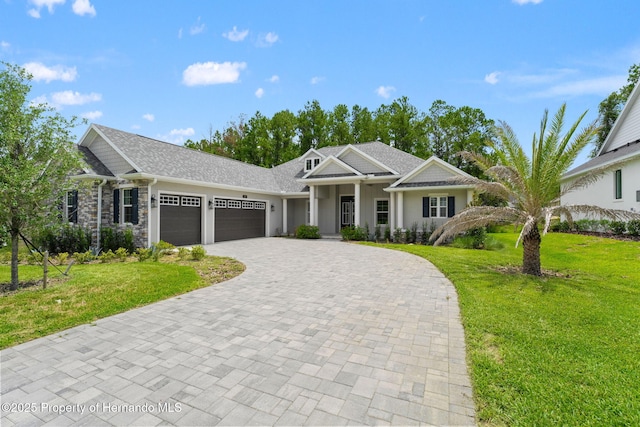 5018 Elm Leaf Dr, Brooksville, FL 34601 - view of front of property featuring a garage, decorative driveway, a front lawn, and stone siding