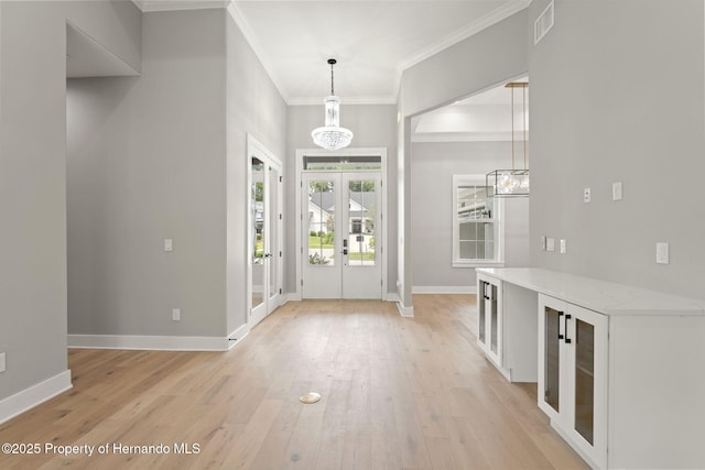 5018 Elm Leaf Dr, Brooksville, FL 34601 - foyer with french doors, crown molding, a chandelier, and light wood-type flooring