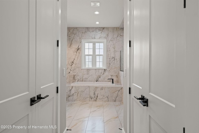 5018 Elm Leaf Dr, Brooksville, FL 34601 - full bath with marble tiled floors, a tub with marble appearance, and recessed lighting