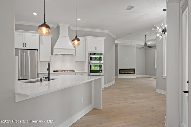 5018 Elm Leaf Dr, Brooksville, FL 34601 - kitchen featuring appliances with stainless steel finishes, crown molding, premium range hood, white cabinetry, and backsplash