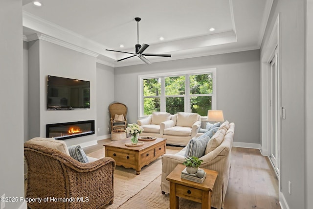 5018 Elm Leaf Dr, Brooksville, FL 34601 - living area with crown molding, a tray ceiling, ceiling fan, recessed lighting, and light wood-style flooring