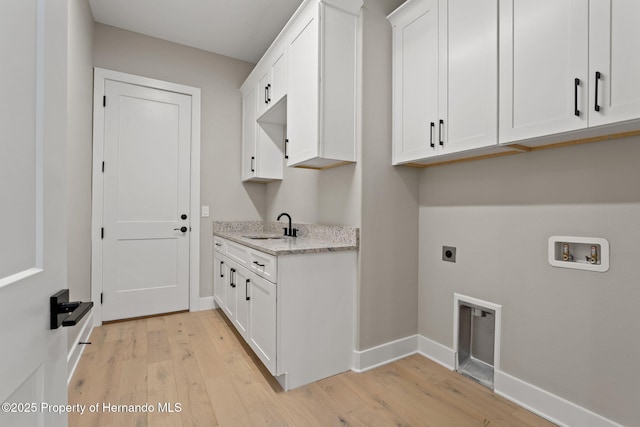 5018 Elm Leaf Dr, Brooksville, FL 34601 - washroom featuring cabinet space, hookup for an electric dryer, light wood-style flooring, and hookup for a washing machine