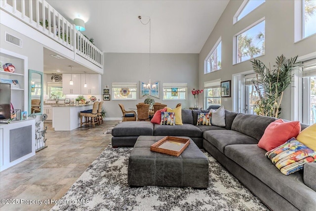 5233 Tuscawilla Dr, Weeki Wachee, FL 34607 - living area featuring a high ceiling, stone finish floors, and a chandelier