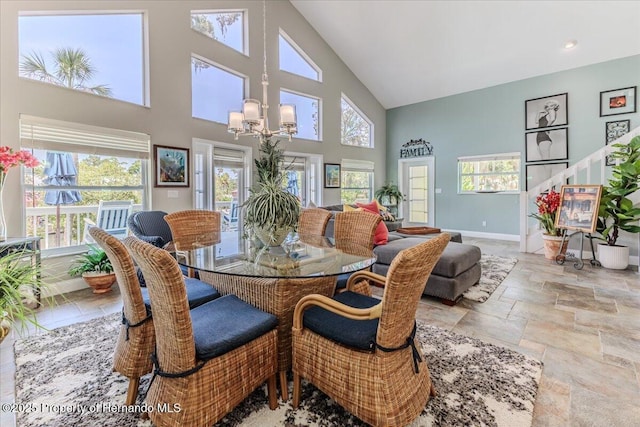 5233 Tuscawilla Dr, Weeki Wachee, FL 34607 - dining room featuring stone tile floors, a chandelier, and high vaulted ceiling