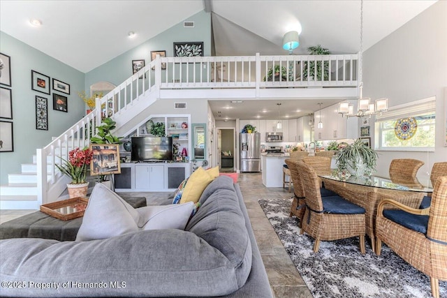 5233 Tuscawilla Dr, Weeki Wachee, FL 34607 - living area with high vaulted ceiling, stairway, and light stone finish floors