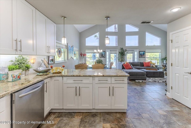 5233 Tuscawilla Dr, Weeki Wachee, FL 34607 - kitchen featuring dishwasher, stone tile floors, a peninsula, white cabinets, and high vaulted ceiling