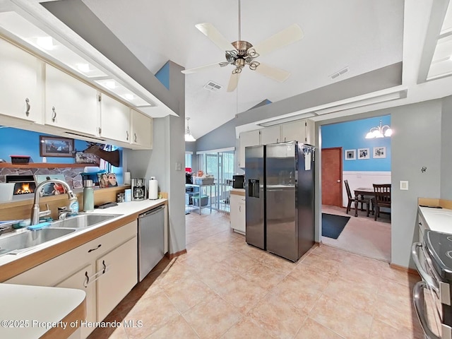 13094 Huntington Woods Ave, Spring Hill, FL 34609 - kitchen with stainless steel appliances, ceiling fan, light countertops, lofted ceiling, and white cabinetry