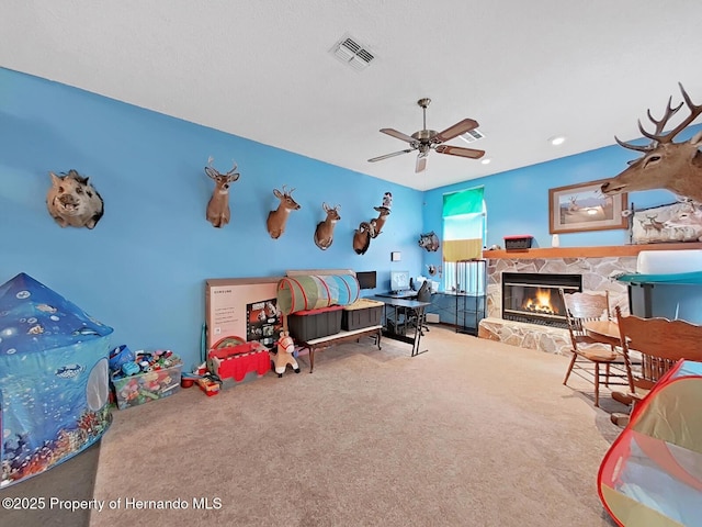 13094 Huntington Woods Ave, Spring Hill, FL 34609 - rec room with carpet flooring, a stone fireplace, and a ceiling fan