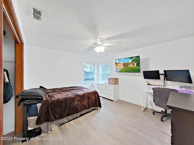 13094 Huntington Woods Ave, Spring Hill, FL 34609 - bedroom featuring wood finished floors, an office area, a textured ceiling, and ceiling fan