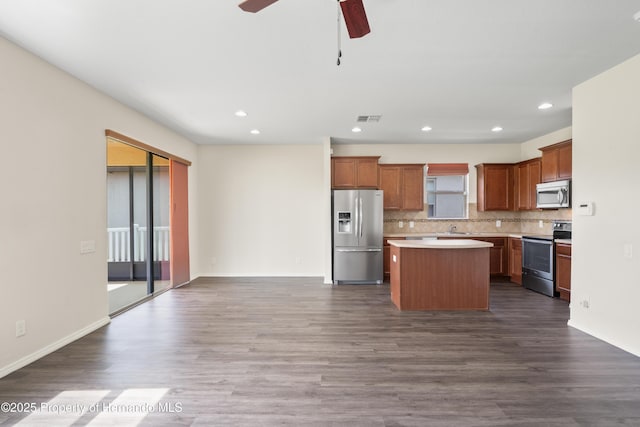 758 Alpine Thistle Dr, Brooksville, FL 34604 - kitchen with stainless steel appliances, a center island, dark wood-type flooring, decorative backsplash, and recessed lighting
