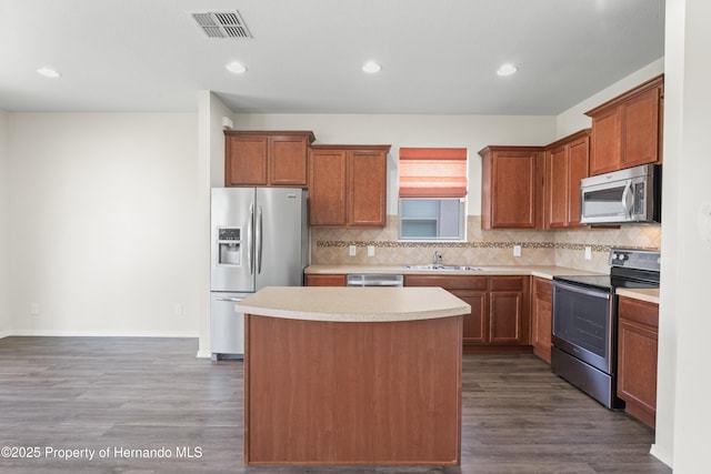 758 Alpine Thistle Dr, Brooksville, FL 34604 - kitchen with stainless steel appliances, a center island, dark wood finished floors, tasteful backsplash, and light countertops