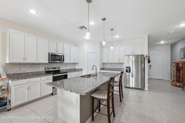 1098 Old Windsor Way, Spring Hill, FL 34609 - kitchen featuring appliances with stainless steel finishes, backsplash, white cabinets, a breakfast bar, and recessed lighting