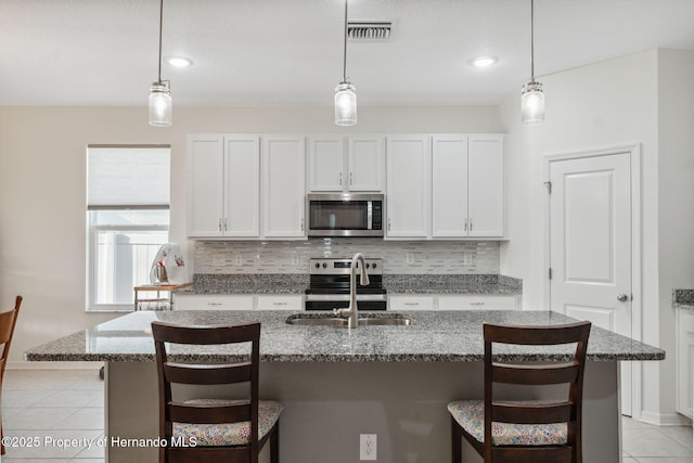 1098 Old Windsor Way, Spring Hill, FL 34609 - kitchen with stainless steel appliances, tasteful backsplash, light tile patterned flooring, white cabinetry, and recessed lighting