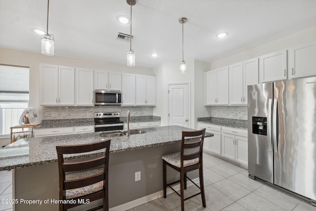 1098 Old Windsor Way, Spring Hill, FL 34609 - kitchen with stainless steel appliances, tasteful backsplash, a breakfast bar, white cabinets, and decorative light fixtures