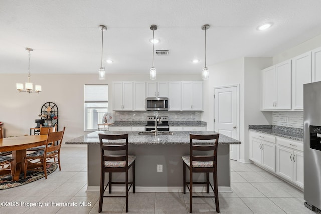 1098 Old Windsor Way, Spring Hill, FL 34609 - kitchen with appliances with stainless steel finishes, tasteful backsplash, light tile patterned floors, a breakfast bar, and white cabinetry