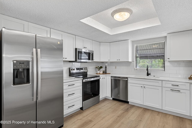 6310 Gainsboro Ave, Spring Hill, FL 34609 - kitchen featuring appliances with stainless steel finishes, a textured ceiling, light countertops, white cabinets, and decorative backsplash