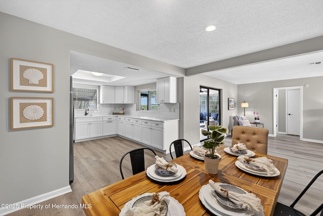 6310 Gainsboro Ave, Spring Hill, FL 34609 - dining room with a textured ceiling, light wood-style flooring, and recessed lighting