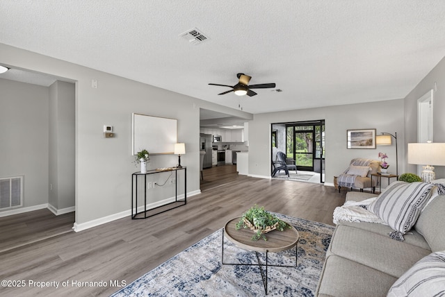 6310 Gainsboro Ave, Spring Hill, FL 34609 - living room with wood finished floors, a ceiling fan, and a textured ceiling