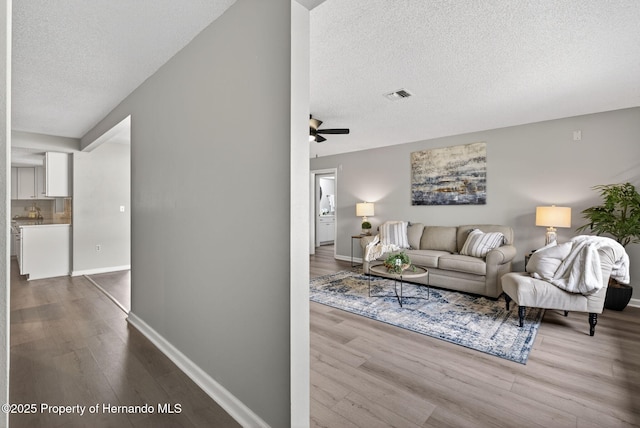 6310 Gainsboro Ave, Spring Hill, FL 34609 - living area featuring a textured ceiling, dark wood-style floors, and a ceiling fan