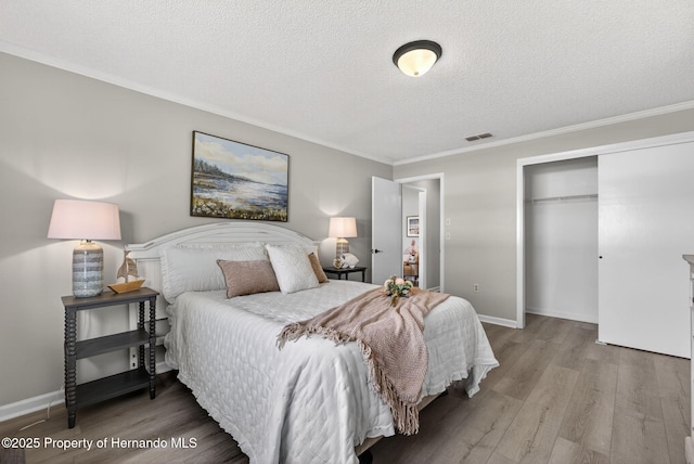 6310 Gainsboro Ave, Spring Hill, FL 34609 - bedroom with a closet, wood finished floors, a textured ceiling, and ornamental molding