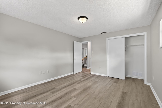 6310 Gainsboro Ave, Spring Hill, FL 34609 - unfurnished bedroom with a textured ceiling, wood finished floors, and a closet